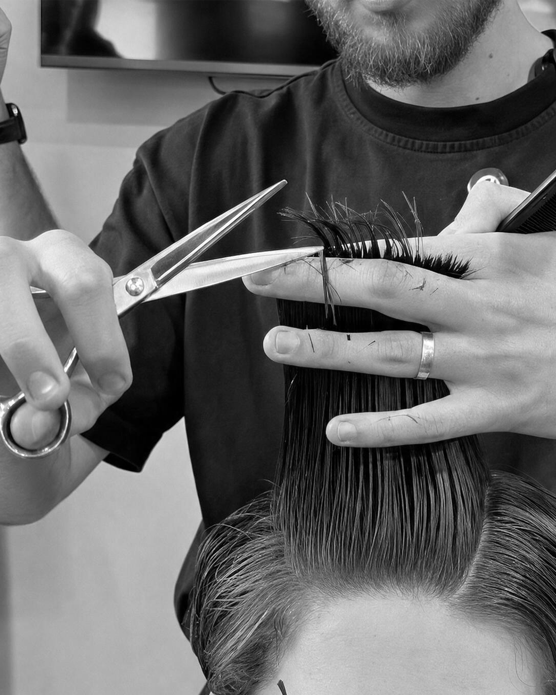 Leo Abreu precisely cutting a client’s hair at OASIS Barbershop